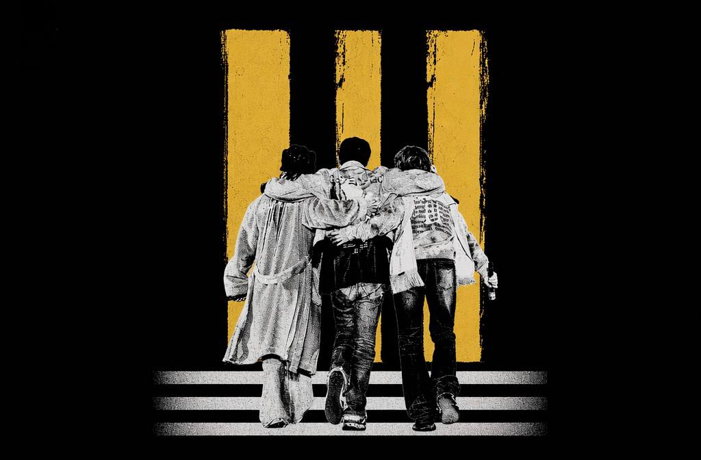 Three BIGBANG members standing together in front of three yellow bars